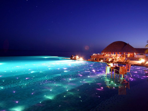 703336_maldives-resort-huvafen-fushi-is-set-up-for-gorgeous-evening-swims-with-colored-lights-twinkling-beneath-the-surface